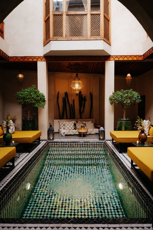 Courtyard with a zellige pool, yellow sofas and lanterns