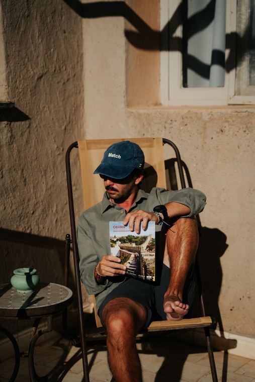Match cap and green linen shirt, sitting in the sun
