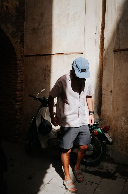 Light shirt and blue cap in a sunlit alley